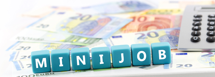 Schriftzug "Minijob" aus Würfeln auf Euroscheinen