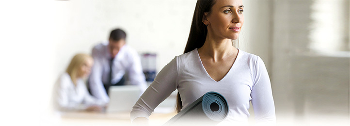 Frau im Büro mit Yogamatte unterm Arm