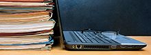 Akten und Laptop auf Schreibtisch