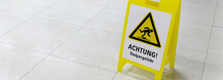 Warnschild mit Stolperhinweis