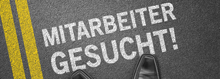 Schriftzug "Mitarbeiter gesucht" auf Asphalt